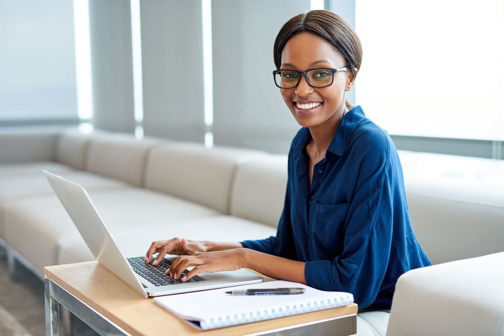 Woman typing on laptop smiling