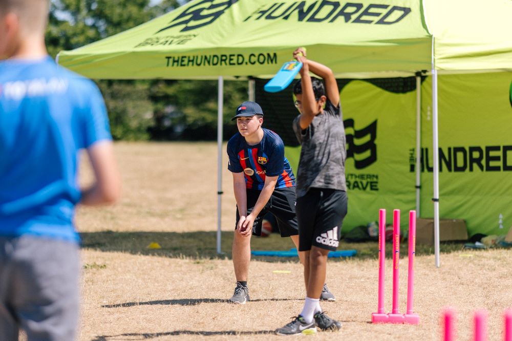 Children playing cricket at VIVD community event