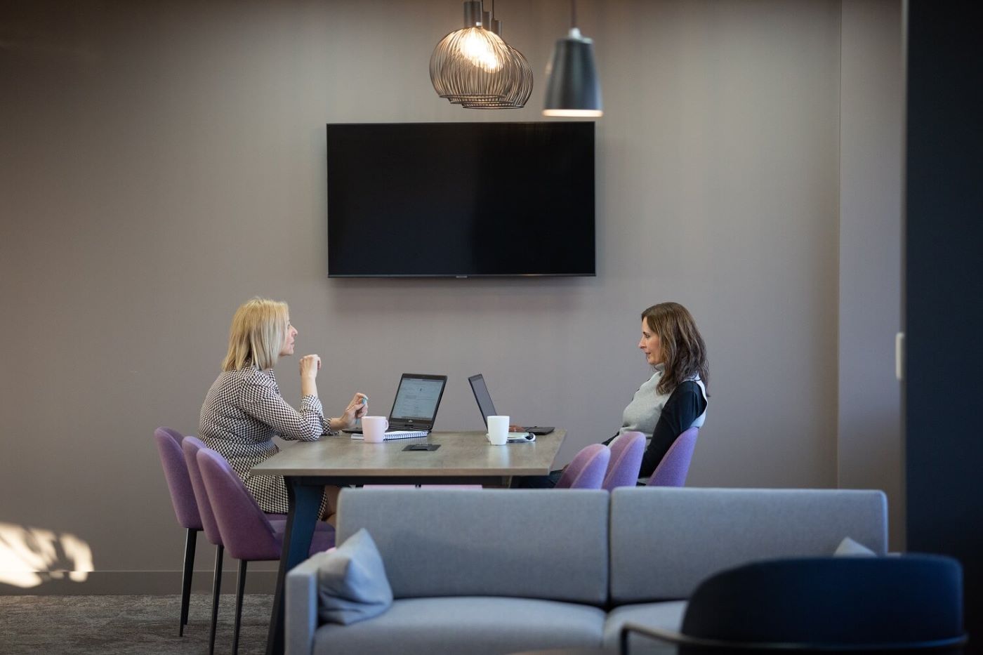 Two staff members talking in a meeting room