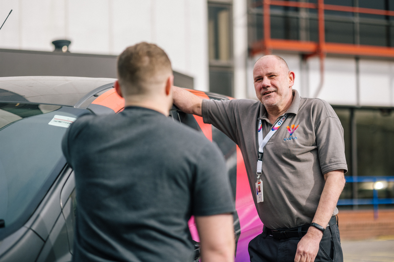 Members of staff talking next to a VIVID van