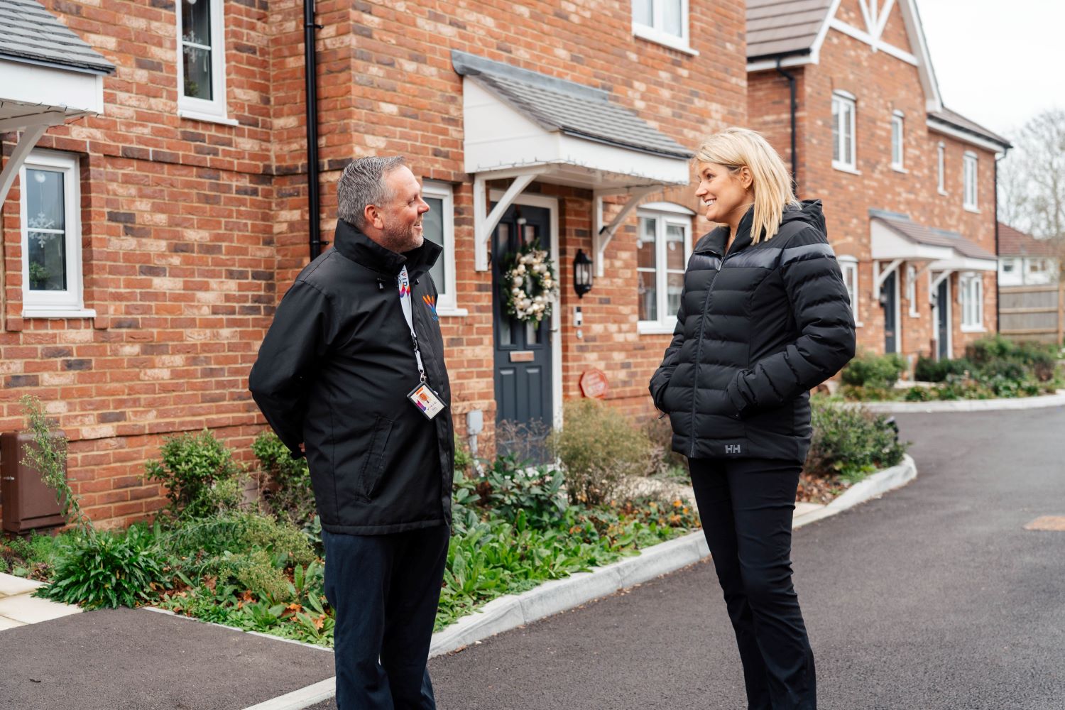 Staff member talking to customer outside a home
